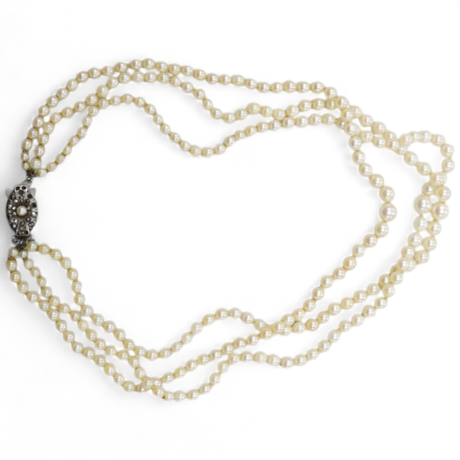 A triple strand graduated cultured pearl necklace, with marcasite set sterling clasp(a.f.), approximately 38cm.
